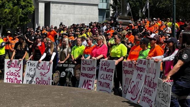 Placards at the CFMEU rally in Brisbane criticise ACTU secretary Sally McManus.