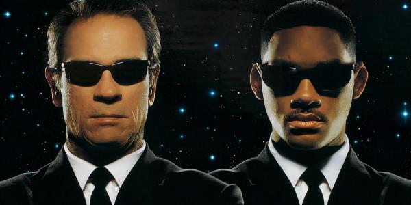 K and J in sunglasses and suits looking serious for the Men In Black poster cropped